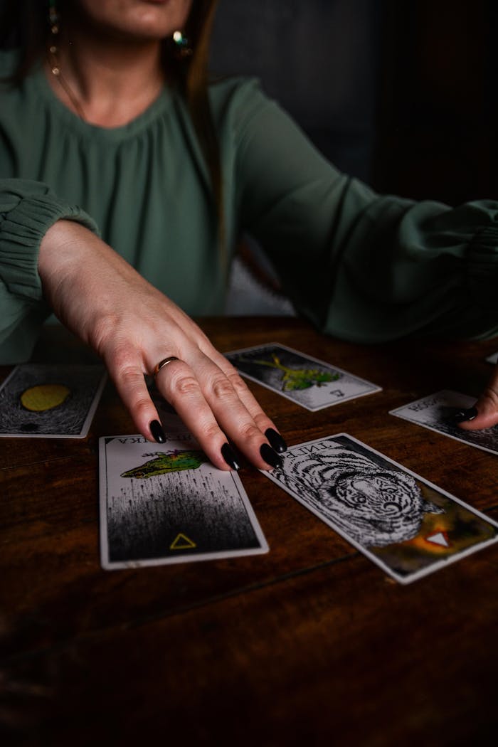 A close-up of a woman performing a tarot reading, emphasizing the tarot cards and hands.